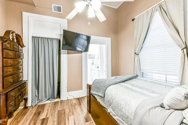 a bedroom with a bed and a flat tv screen on dresser