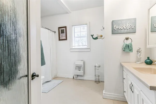 a bathroom with a sink vanity and a window