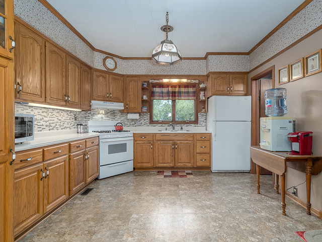 17447 West 2000N Road Reddick, IL 60961 - Photo 10 of 37 a kitchen with granite countertop a refrigerator a sink and white cabinets