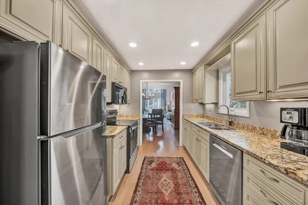 a kitchen with stainless steel appliances granite countertop refrigerator sink and cabinets