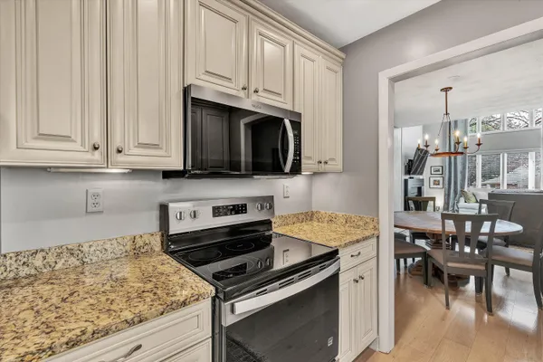 a kitchen with stainless steel appliances granite countertop a stove and a microwave