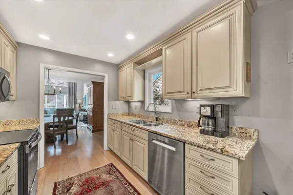 a kitchen with stainless steel appliances granite countertop a sink stove and cabinets