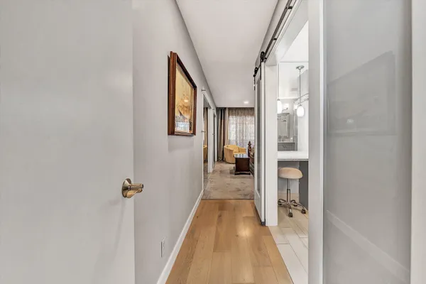 a view of a hallway with a livingroom and a bathroom with sink