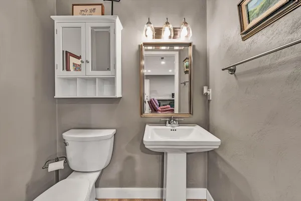 a bathroom with a toilet sink and mirror