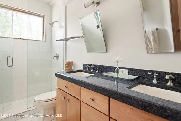 a bathroom with a granite countertop sink mirror vanity and toilet