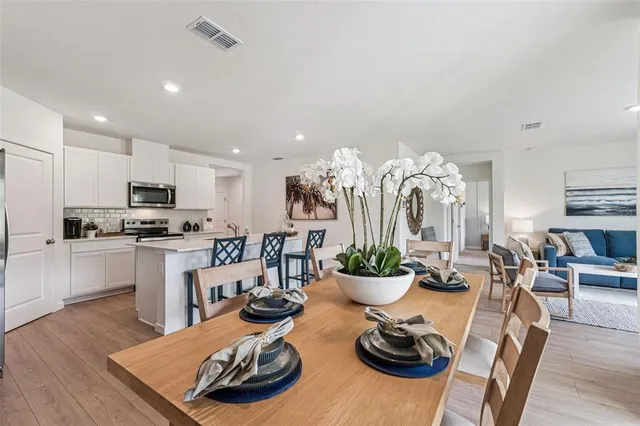 a kitchen with sink refrigerator dining table and chairs