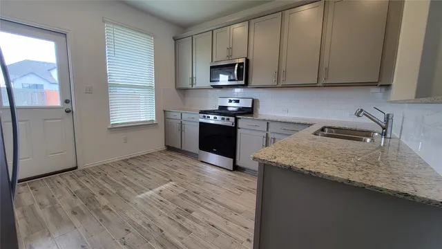 a kitchen with granite countertop wooden cabinets and a stove