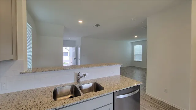 a kitchen with a sink cabinets and a wooden floor