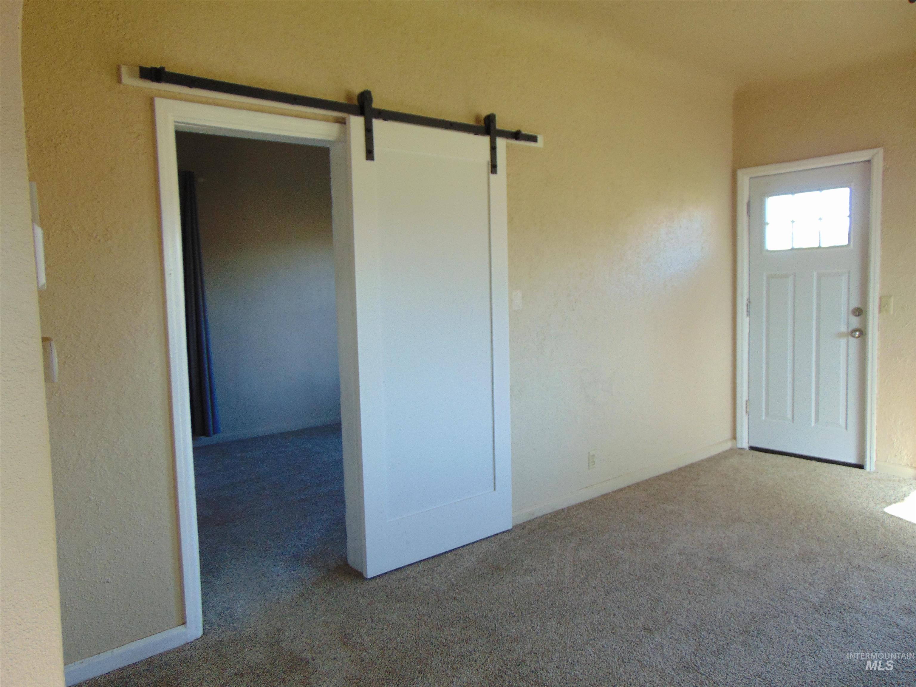 2933 2nd Street Harper, OR 97906 - Photo 20 of 28 Entrance foyer featuring a barn door, carpet floors, and a textured wall