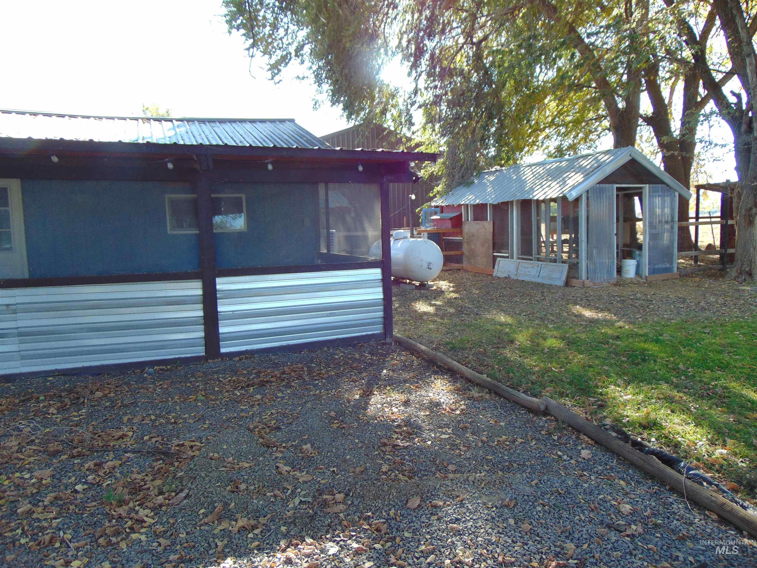 2933 2nd Street Harper, OR 97906 - Photo 2 of 28 Back of property featuring a metal roof, a sunroom, and an outbuilding