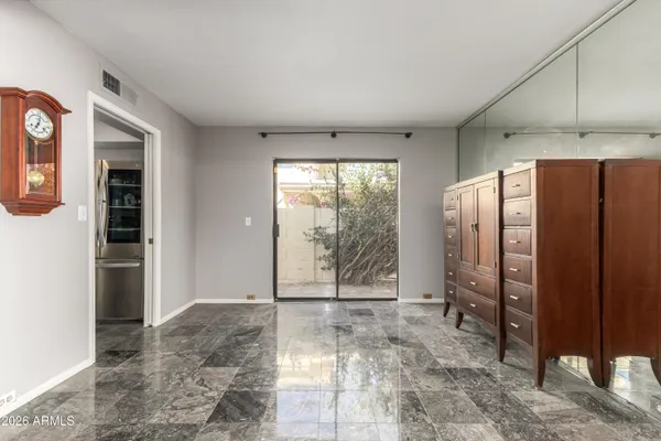 an empty room with windows and fan