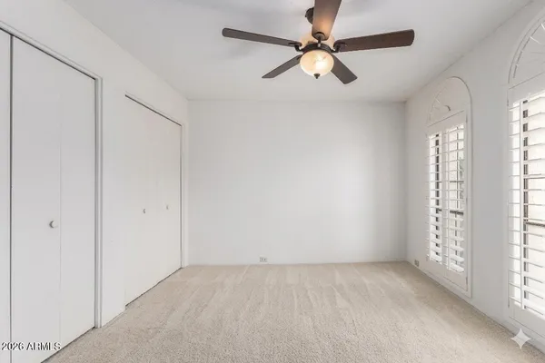a view of an empty room with window and cabinet