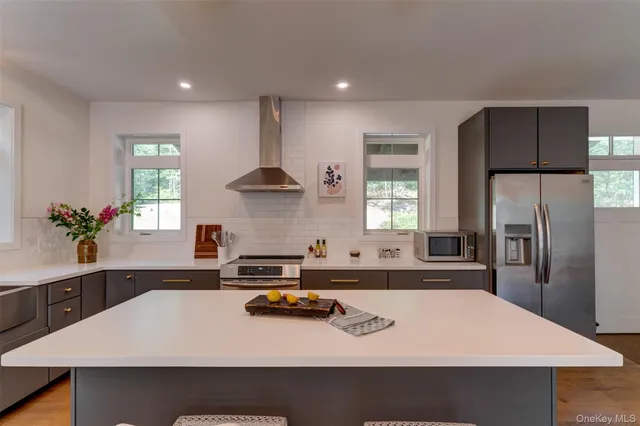 a kitchen with kitchen island a sink stainless steel appliances and window