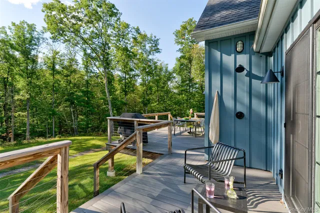 a balcony with wooden floor table and chairs