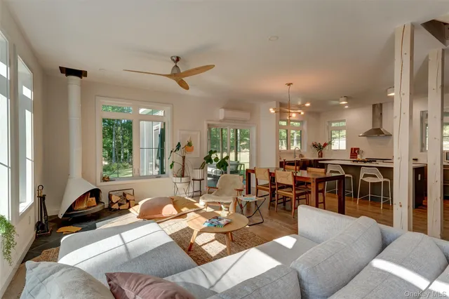 a living room with furniture kitchen view and a large window