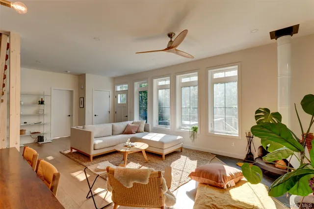 a living room with furniture floor to ceiling window and a flat screen tv