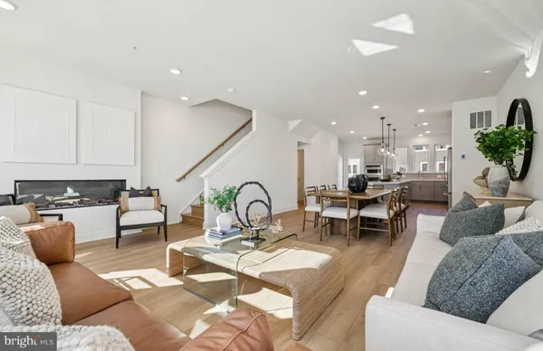 a living room with furniture kitchen view and a potted plant