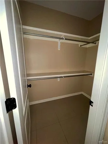 an empty room with a ceiling fan and carpet