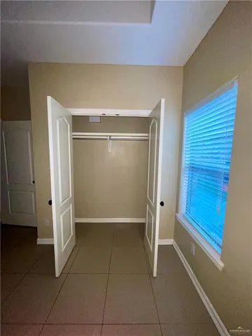 an empty room with a ceiling fan and carpet