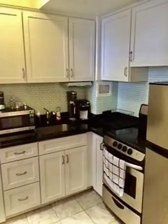 a kitchen with white cabinets and appliances
