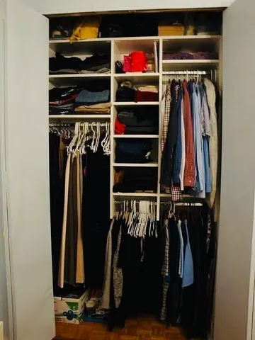 a view of walk in closet with clothes and shoes