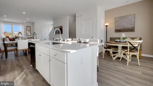 a kitchen with a sink table and chairs