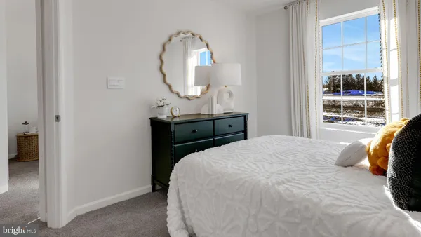 a bedroom with a bed a mirror and a large window