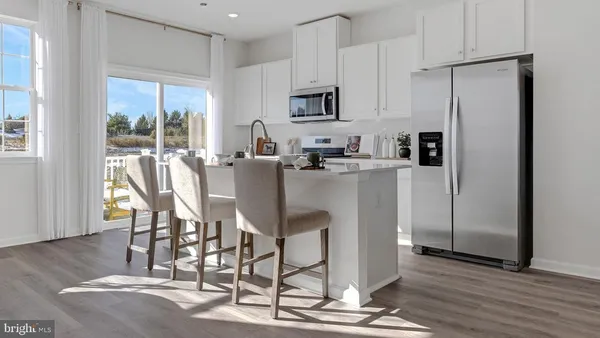 a kitchen with stainless steel appliances granite countertop a stove a refrigerator a microwave a sink and cabinets