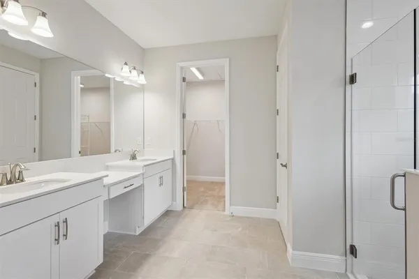 a bathroom with a double vanity sink toilet mirror and windows