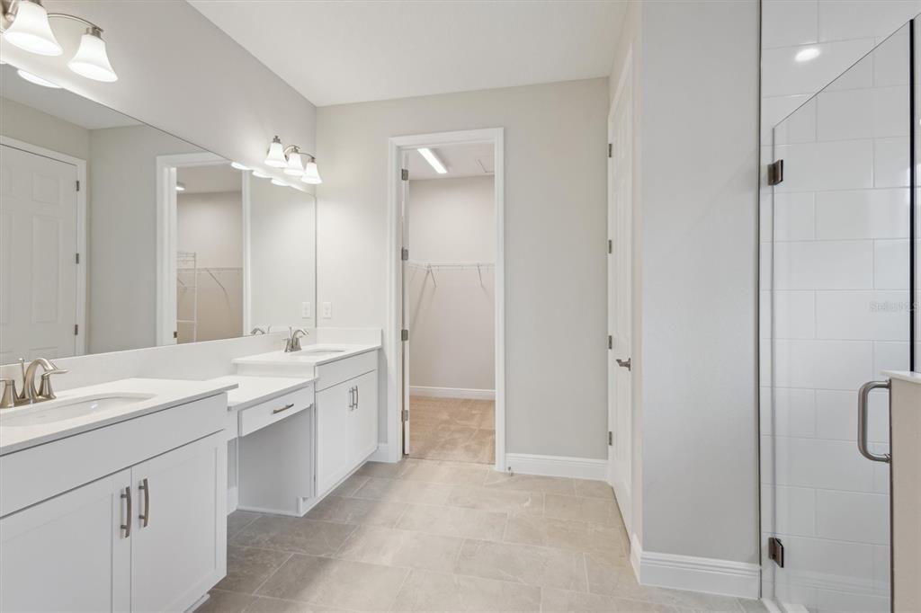5178 Everlong Drive Apollo Beach, FL 33572 - Photo 7 of 25 a bathroom with a double vanity sink toilet mirror and windows