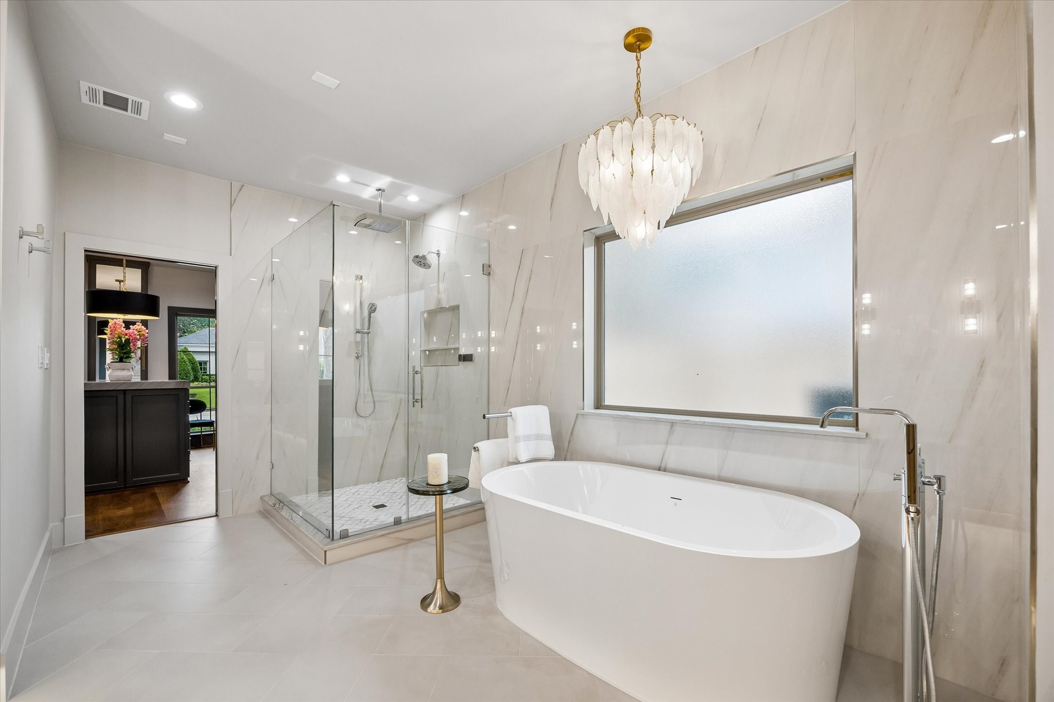620 Stoneleigh Drive Houston, TX 77079 - Photo 18 of 39 A BainUltra freestanding soaking tub is perfectly positioned alongside towel warmers, while a mosaic marble shower floor with a designer chrome drain adds a sophisticated touch. Brizo Allari fixtures in chrome with Lucite handles pair beautifully with an advanced Kohler Anthem digital shower system, offering personalized temperature settings and control of the rain, handheld, and traditional shower heads.
