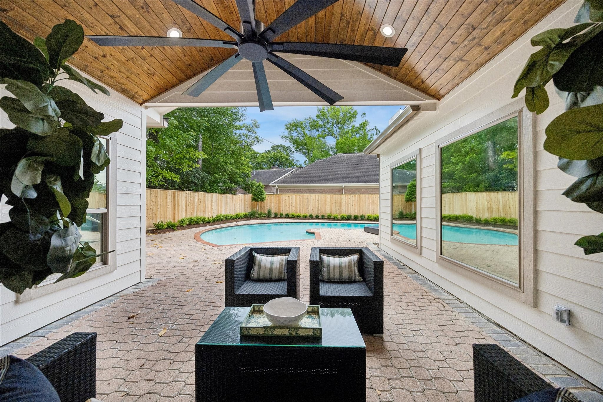620 Stoneleigh Drive Houston, TX 77079 - Photo 34 of 39 Covered patio with a stained tongue-and-groove ceiling, thoughtfully designed to be enjoyed from multiple rooms throughout the home, creating a natural extension of the living spaces.