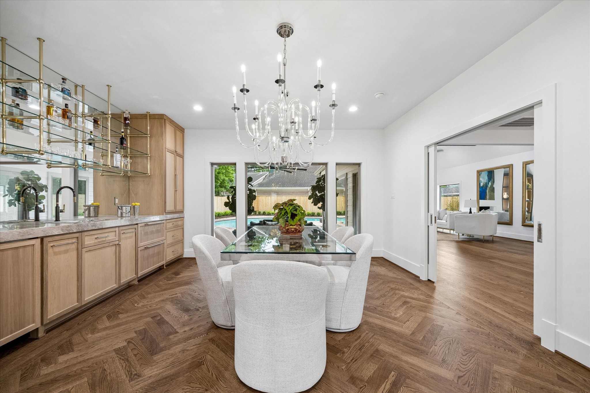 620 Stoneleigh Drive Houston, TX 77079 - Photo 6 of 39 The dining room features crystal chandeliers in polished nickel, casting a soft, elegant glow throughout the space. A striking New Taj Mahal quartzite countertop with a 3” miter edge runs the length of the room, while a large picture window overlooks the covered patio and pool. A wide opening leads directly into the kitchen and family room, creating an easy, connected flow for daily living and entertaining.