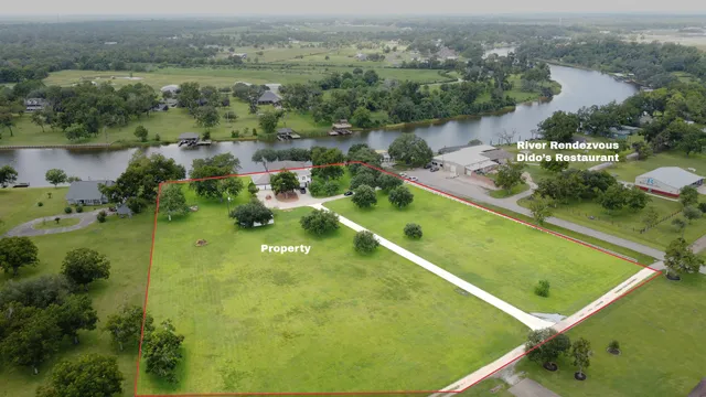 an aerial view of lake with residential houses with outdoor space and trees