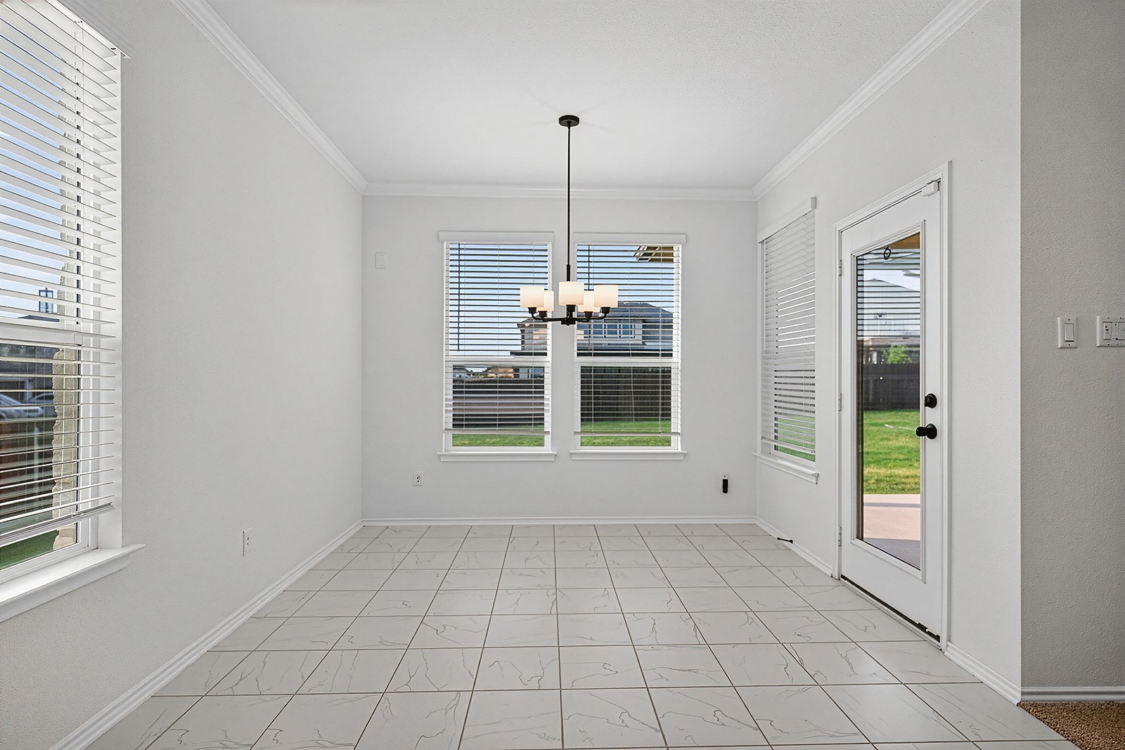 4600 Ercolano Lane Round Rock, TX 78665 - Photo 13 of 37 Bright interior space featuring light-toned tile flooring, white walls, and elegant crown molding