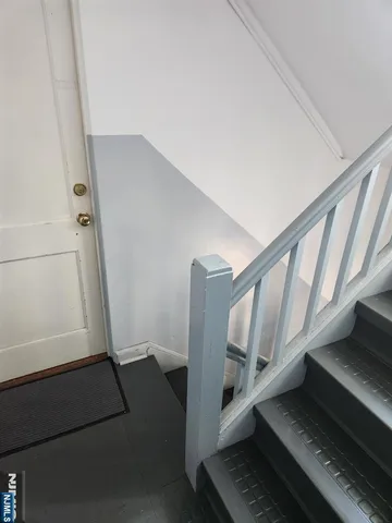 a view of staircase with lots of white furniture