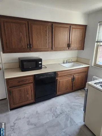 a kitchen with stainless steel appliances granite countertop a sink a stove a refrigerator and cabinets