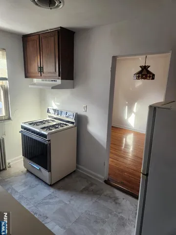 a view of kitchen with stainless steel appliances cabinets and a stove top oven