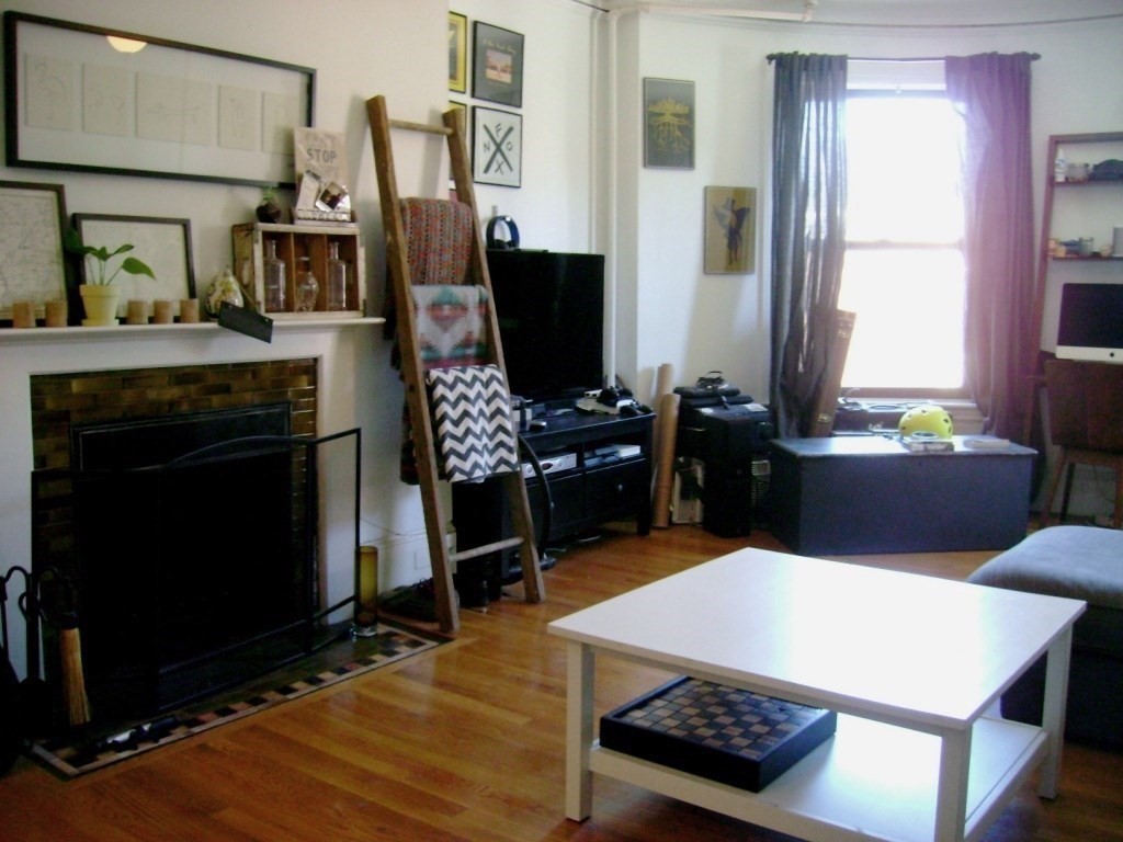 924 Beacon Street, Unit 6 Boston, MA 02215 - Photo 4 of 28 a living room with furniture a flat screen tv and a fireplace
