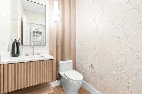 a bathroom with a sink a toilet and a mirror