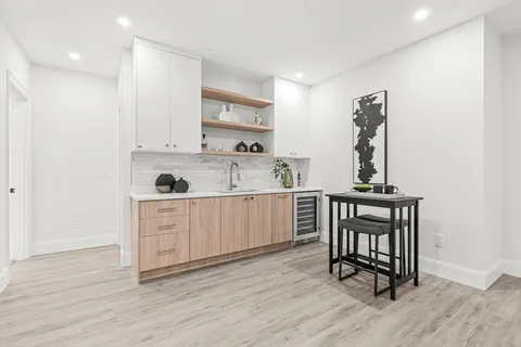 a kitchen with wooden floors and white cabinets