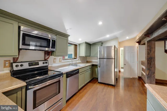 a kitchen with stainless steel appliances a stove microwave and a refrigerator