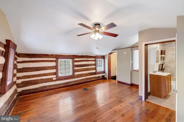 a view of a room with wooden floor and a ceiling fan