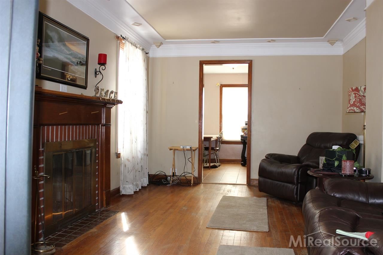 2936 Harvey Street Rochester, MI 48309 - Photo 3 of 29 Hardwood floors and a natural fireplace anchor this great living room. Situated next to the dining room, there is nice flow to this home.
