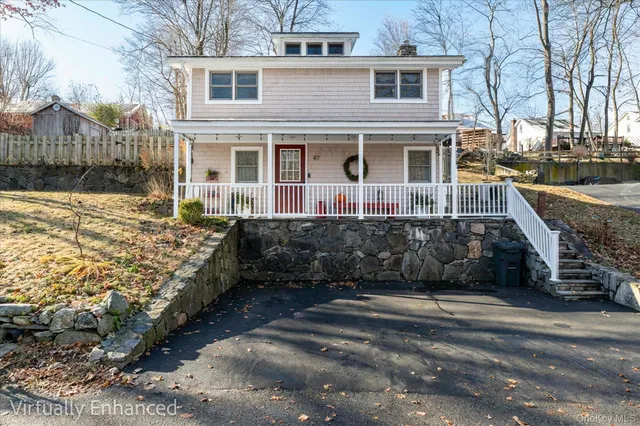 a front view of a house with a yard covered with snow