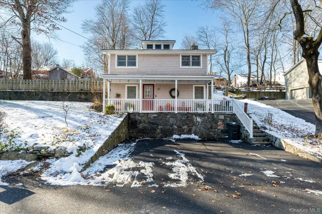 a front view of a house with a yard covered with snow