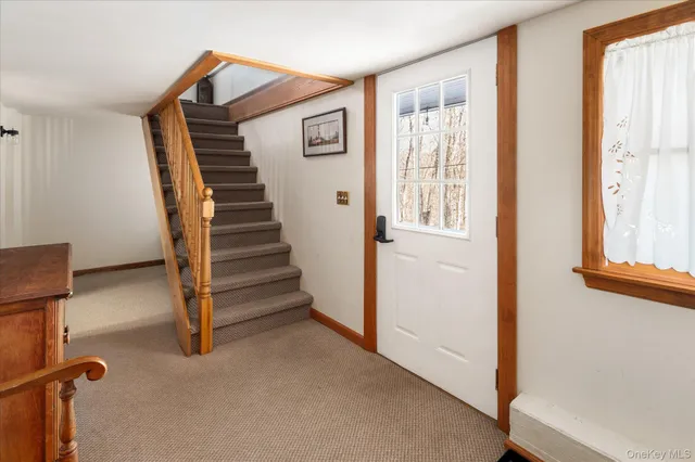 a view of a livingroom with wooden floor and stairs