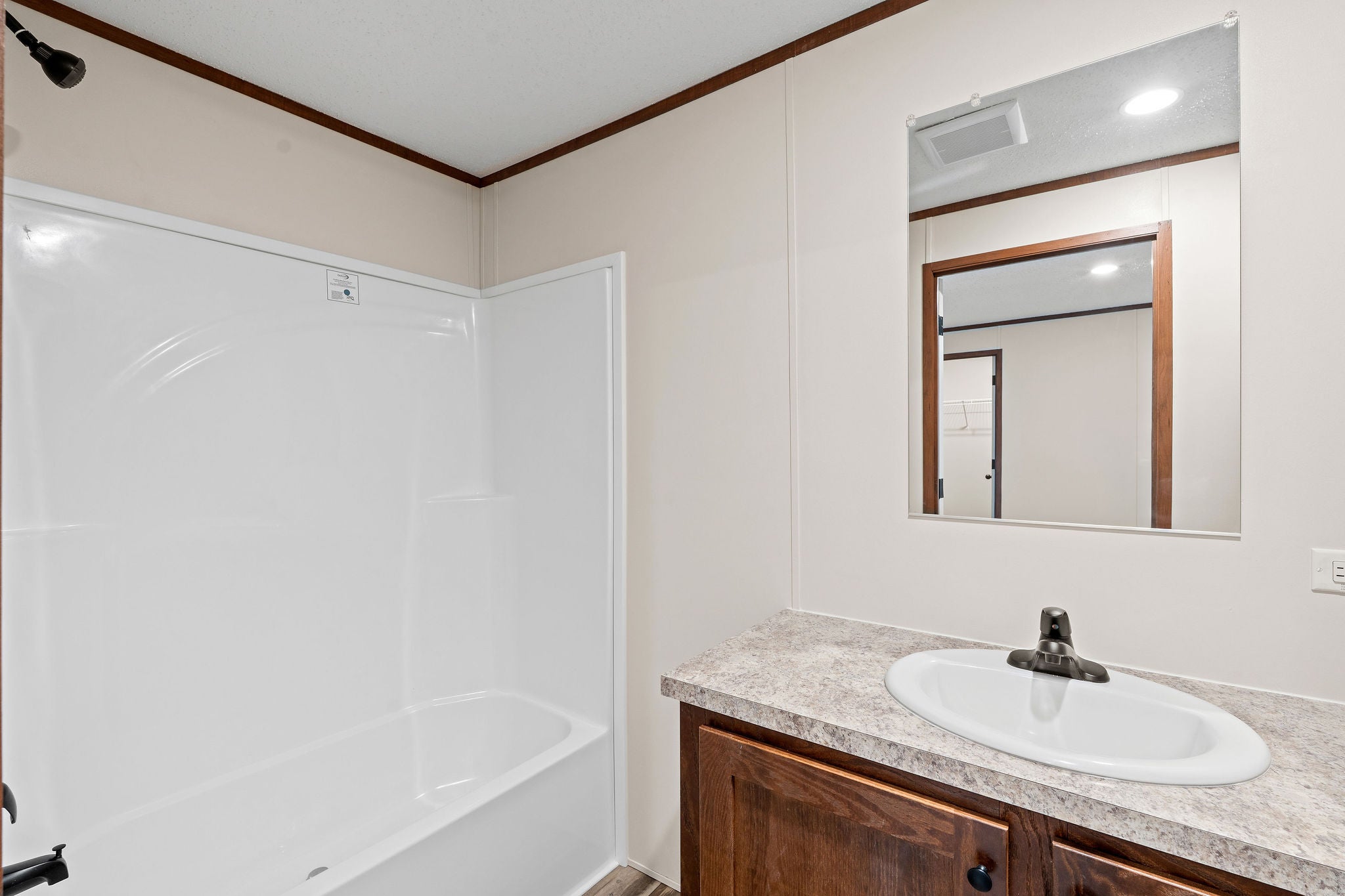 110 Van Sant Road, Unit 15 Kalispell, MT 59901 - Photo 16 of 22 Primary bathroom vanity featuring Belmonte Granite countertop, white oval sink, and a clean tub/shower combo