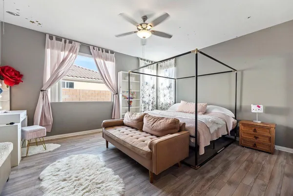 a bedroom with a bed couch and a window