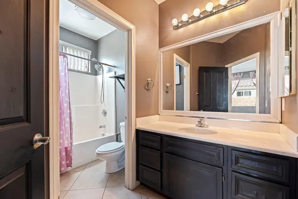 a bathroom with a sink a toilet a large mirror and shower